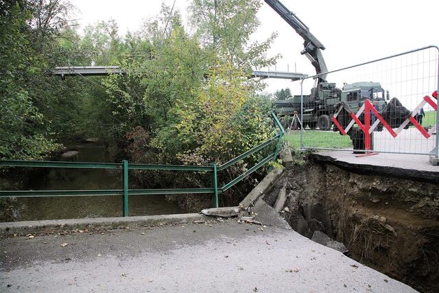 Die Melker Pioniere heben einen knapp 20 Meter langen Hilfssteg ein. Im Vordergrund ist die beschädigte Brücke zu sehen. (Foto: Bundesheer/Felix Höbarth)